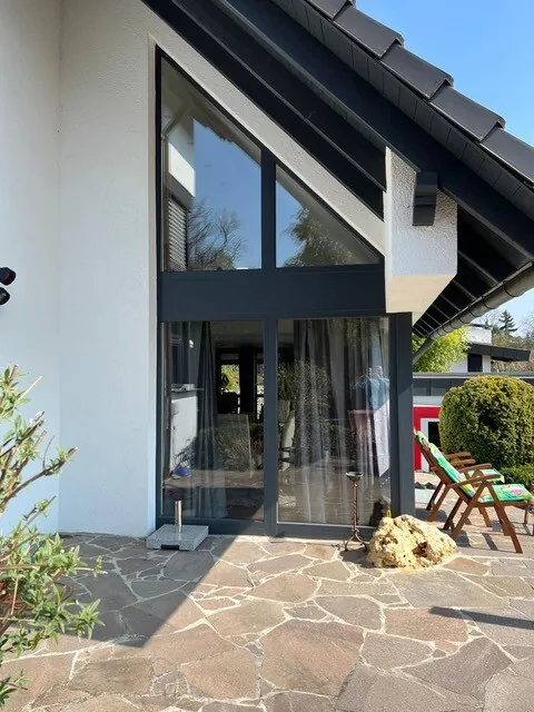 Eingangsbereich eines Einfamilienhauses mit großer Glasfront in Anthrazit