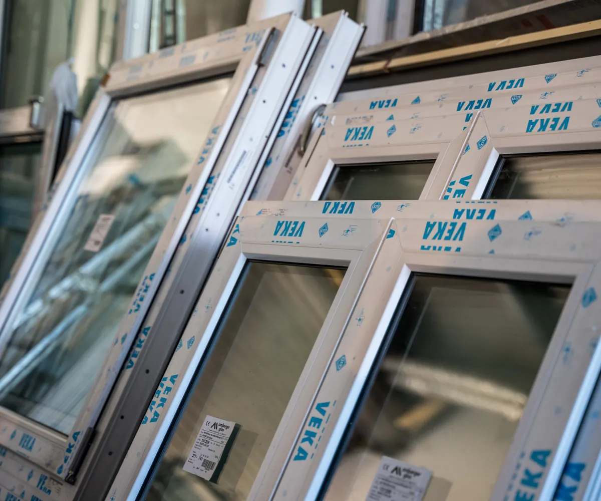 Neue Fenster mit VEKA-Schutzfolie, gestapelt und bereit für die Montage